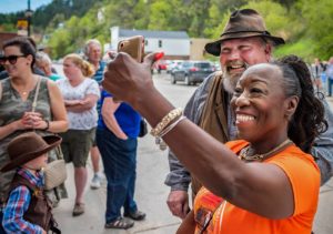 woman taking picture with re-enactors downtown Deadwood