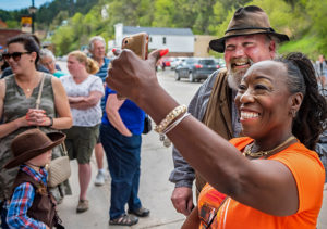 woman taking picture with re-enactors downtown Deadwood