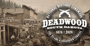 A historical black and white photograph taken in Deadwood, SD. With a white logo that says "National Historic Landmark. Deadwood, South Dakota. 1876-2026. 150 Years. Sesquicentennial"