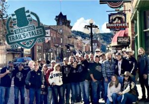 Picture of a large group of people on Deadwood main street on a sunny day.