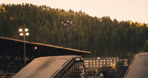 Photo of a racer in the middle of a jump on a dirtbike over an inflatable ramp.