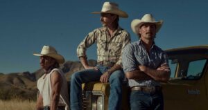 The band Midland dressed in cowboy hats. They are sitting on the hood of a vintage gold truck.