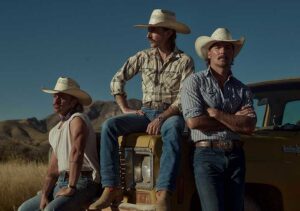 The band Midland dressed in cowboy hats. They are sitting on the hood of a vintage gold truck.